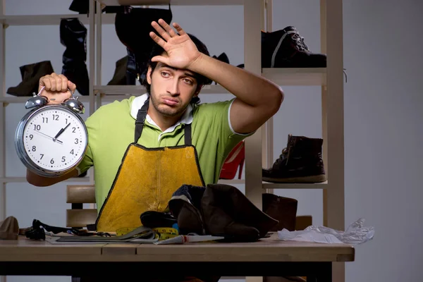 Young shoemaker in workshop at night — Stock Photo, Image