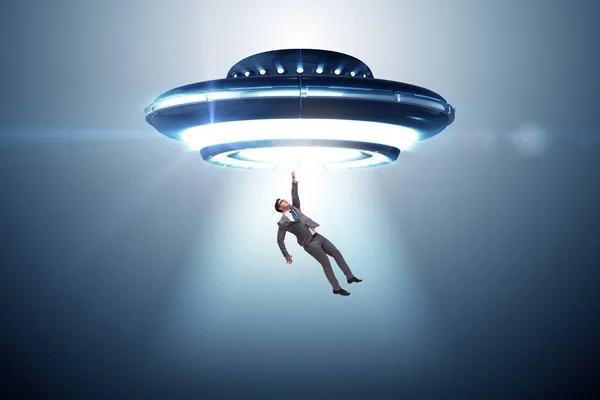 Flying saucer abducting young businessman — Stock Photo, Image