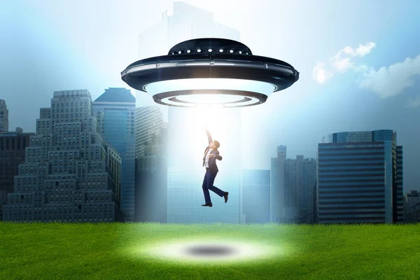 Flying saucer abducting young businessman — Stock Photo, Image