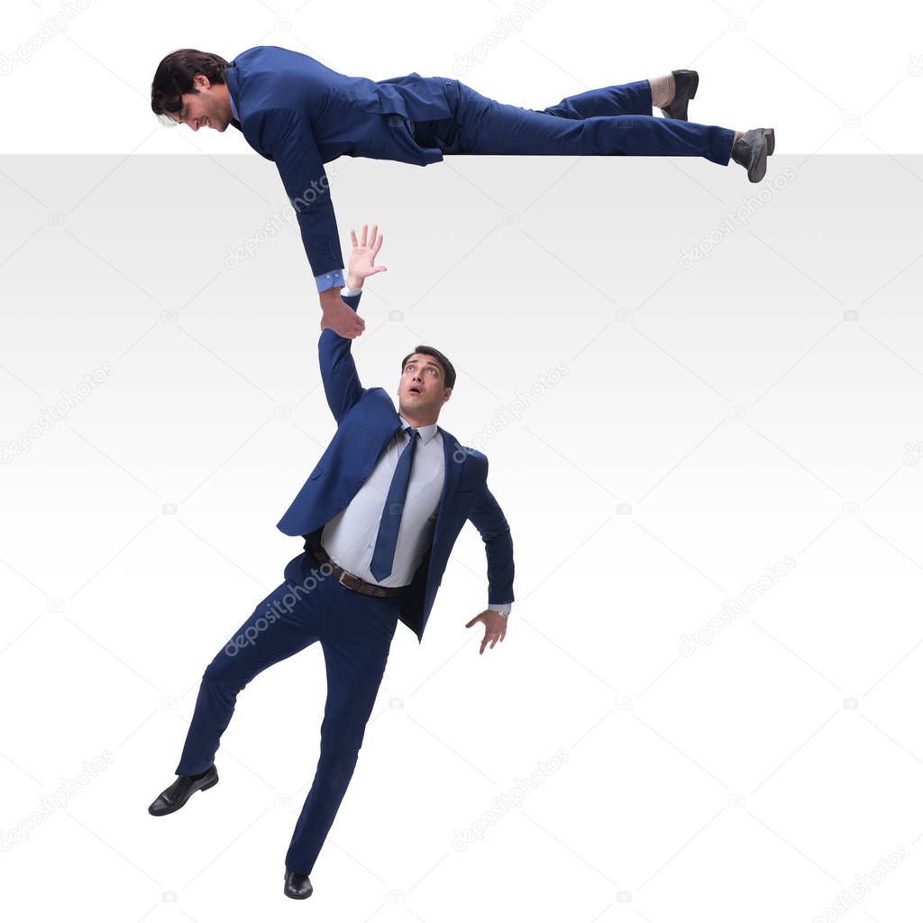 Businessman offering helping hand to falling colleague