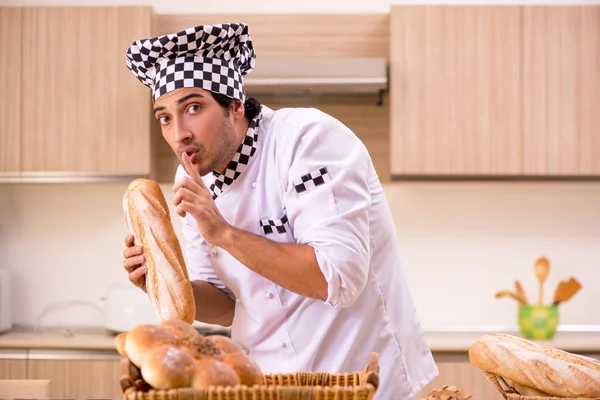 Young male baker working in kitchen — Stock Photo, Image