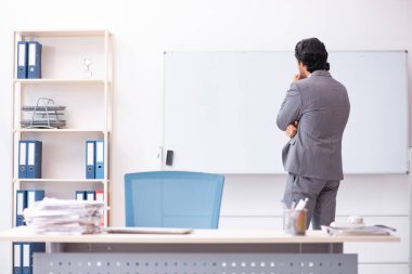 Beyaz tahta önünde duran genç yakışıklı işadamı 