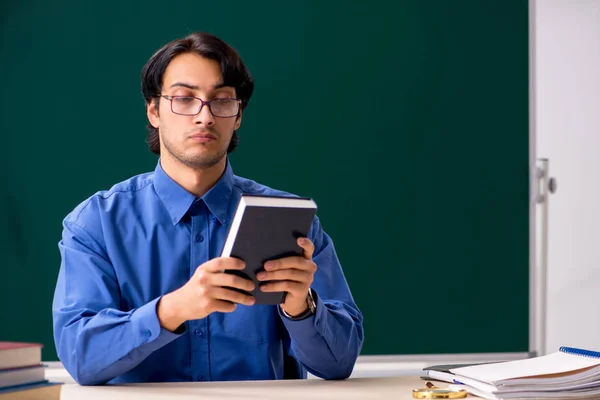 Jeune professeur masculin devant un tableau noir — Photo