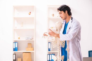 İskeleti olan genç erkek doktor. 