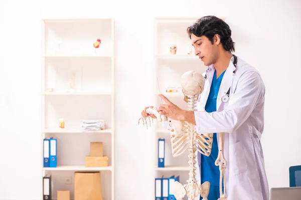 Joven médico varón con esqueleto — Foto de Stock