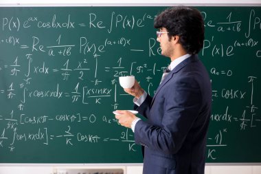 Genç erkek matematik öğretmeni sınıfta 