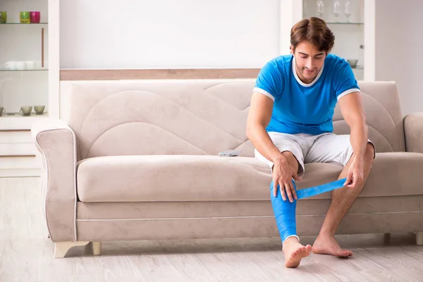 Jambe blessée jeune homme sur le canapé — Photo