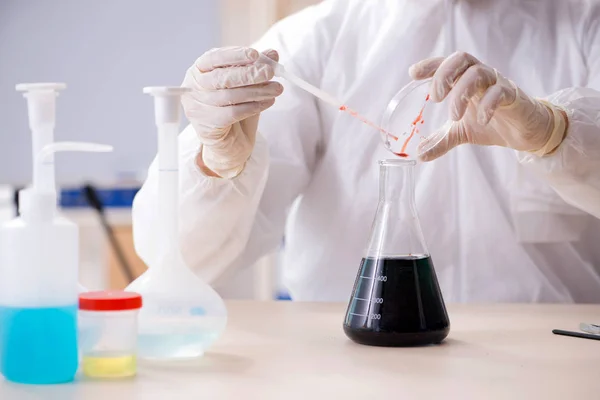 stock image Young handsome chemist working in the lab 