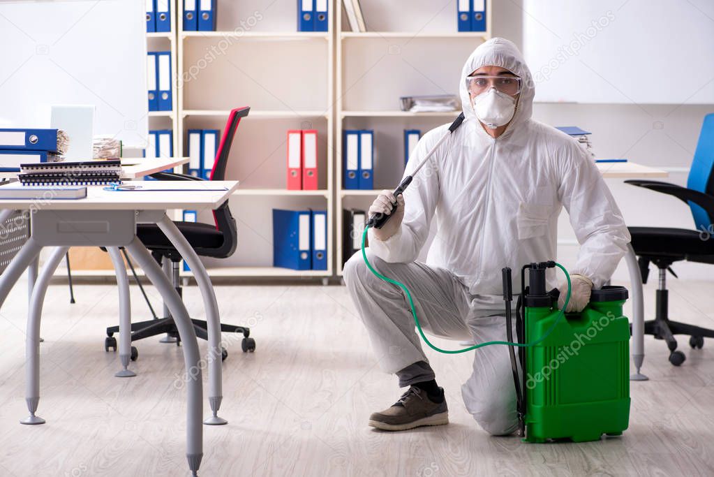Professional contractor doing pest control at office 
