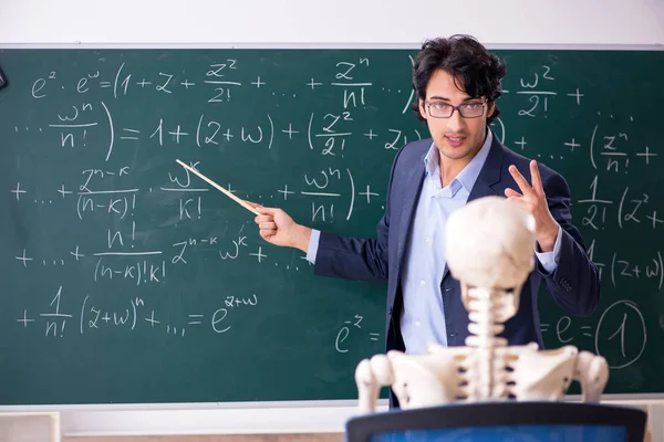 Молодой учитель математики и студенческий скелет — стоковое фото