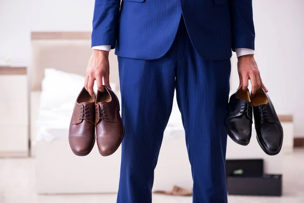 Jovem empresário bonito escolhendo sapatos em casa — Fotografia de Stock