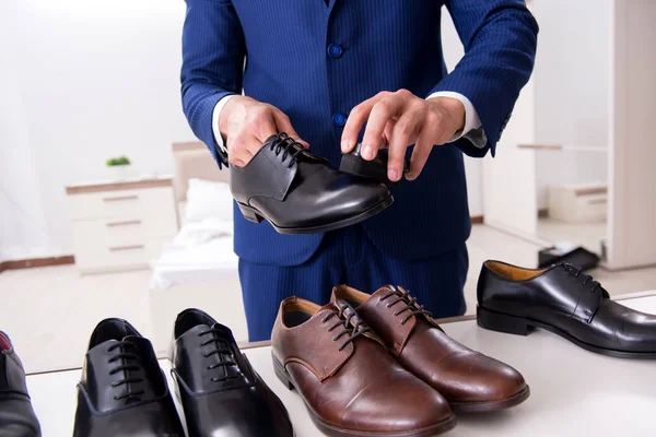 Jovem empresário bonito escolhendo sapatos em casa — Fotografia de Stock