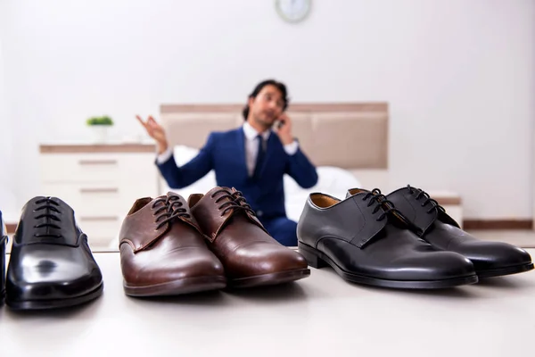 Young handsome businessman choosing shoes at home — Stock Photo, Image