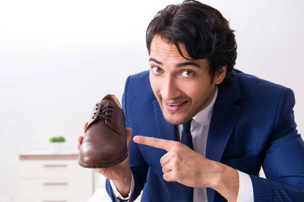 Jovem empresário bonito escolhendo sapatos em casa — Fotografia de Stock