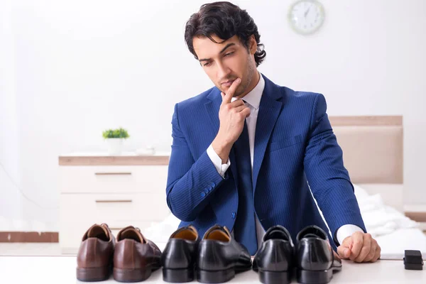 Jovem empresário bonito escolhendo sapatos em casa — Fotografia de Stock