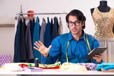 Atölyede çalışan genç bir terzi. 