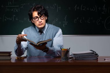 Kara tahta önünde genç matematik öğretmeni