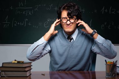 Kara tahta önünde genç matematik öğretmeni