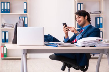 Genç yakışıklı işadamı ofiste oturuyor. 