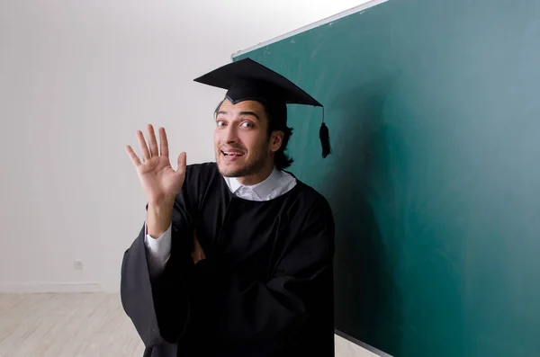 Estudante graduado na frente do quadro verde — Fotografia de Stock