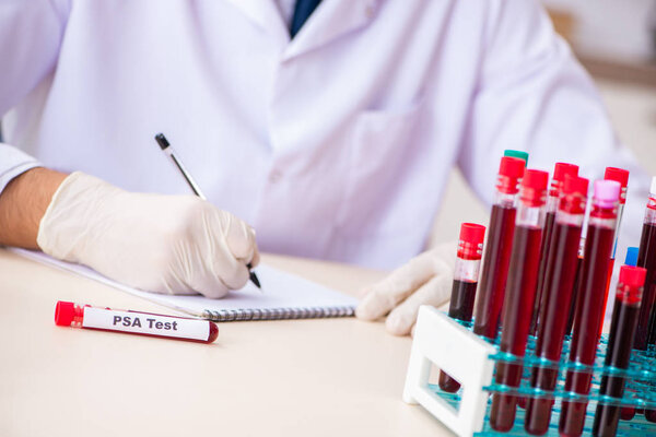 Young handsome lab assistant testing blood samples in hospital 