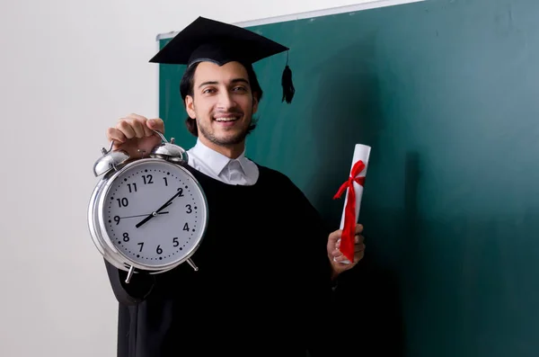 Estudante graduado na frente do quadro verde — Fotografia de Stock