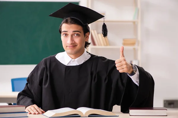 Estudante graduado na frente do quadro verde — Fotografia de Stock