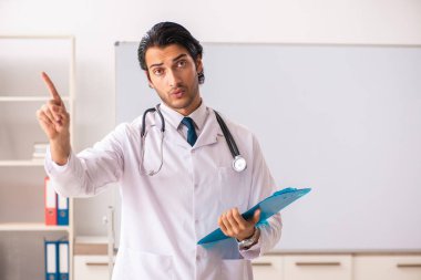 Genç doktor beyaz tahtanın önünde. 