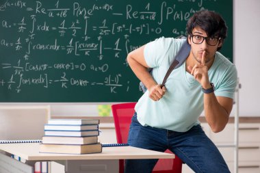 Kara tahta önünde genç erkek öğrenci matematikçi 