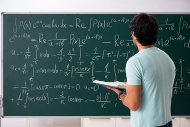 Kara tahta önünde genç erkek öğrenci matematikçi 