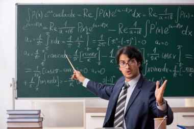 Genç erkek matematik öğretmeni sınıfta 