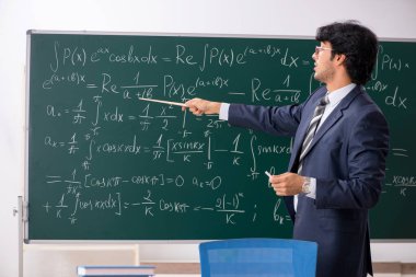 Genç erkek matematik öğretmeni sınıfta 