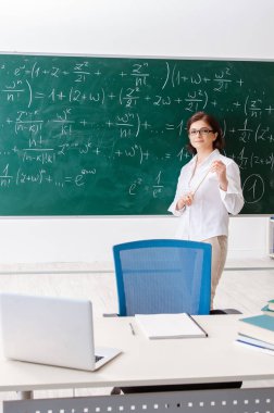 Kara tahta önünde kadın matematik öğretmeni 