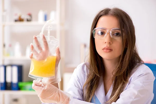 Assistente femminile con sacca di plasma in laboratorio — Foto Stock