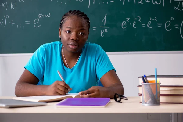 Svart kvinnlig student framför svarta tavlan — Stockfoto