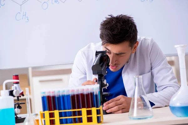 Joven químico sentado en el laboratorio —  Fotos de Stock