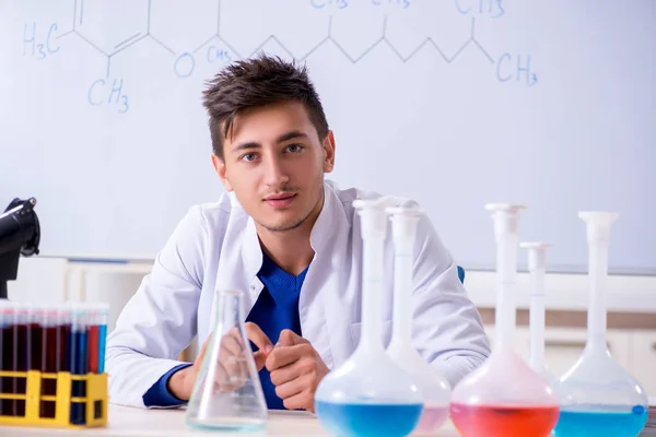 Joven químico sentado en el laboratorio — Foto de Stock