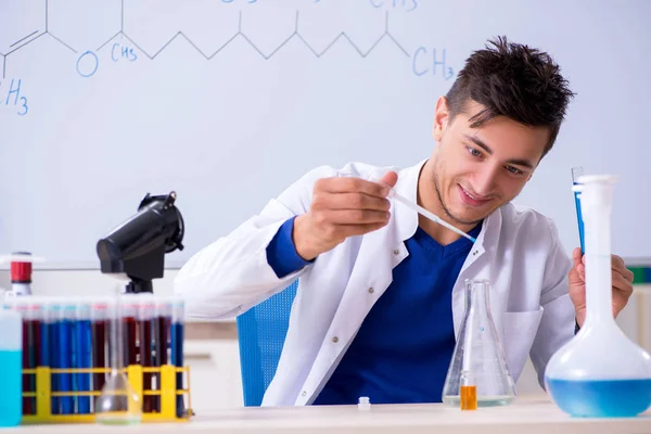 Jovem químico sentado no laboratório — Fotografia de Stock