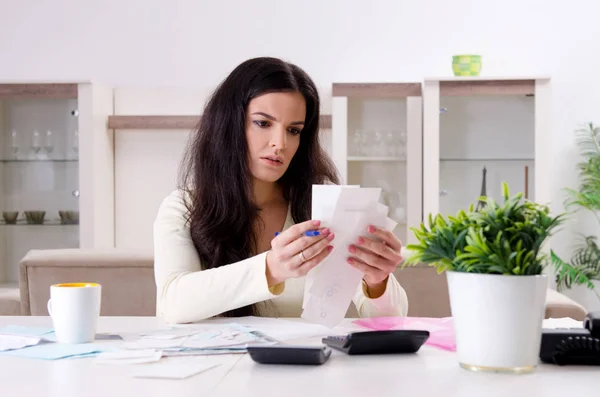 Young woman with receipts in budget planning concept — Stock Photo, Image