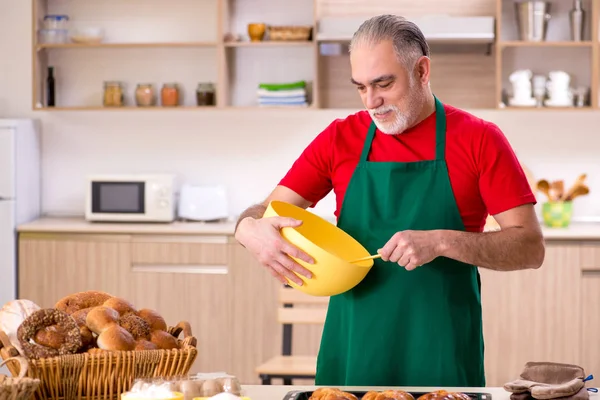 Starý muž baker práci v kuchyni — Stock fotografie