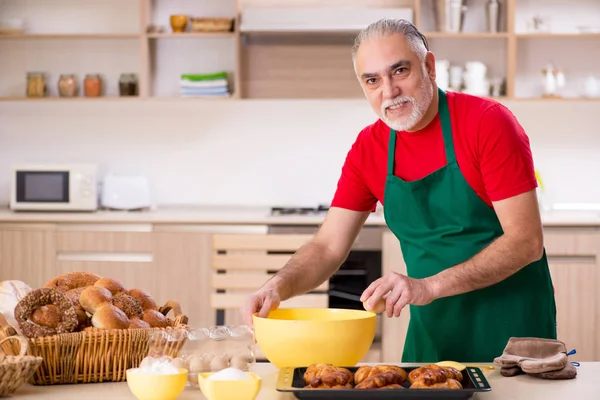 Alter männlicher Bäcker arbeitet in der Küche — Stockfoto