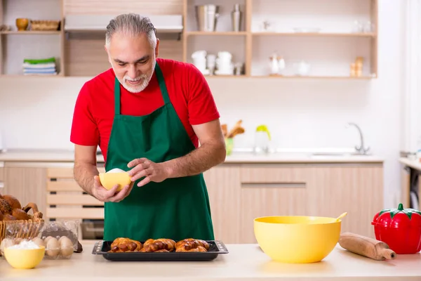 Alter männlicher Bäcker arbeitet in der Küche — Stockfoto