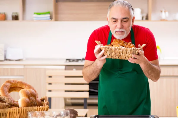 Oude mannelijke baker werken in de keuken — Stockfoto