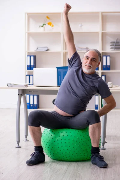 Ofis egzersizleri yapıyor yaşlı adam çalışan beyaz sakallı — Stok fotoğraf