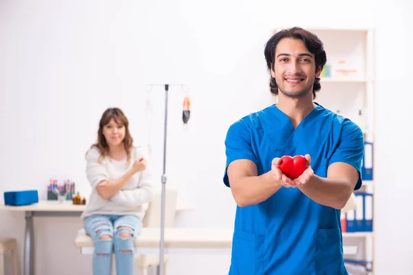 Jovem focador do sexo masculino e paciente do sexo feminino em transfusão de sangue — Fotografia de Stock