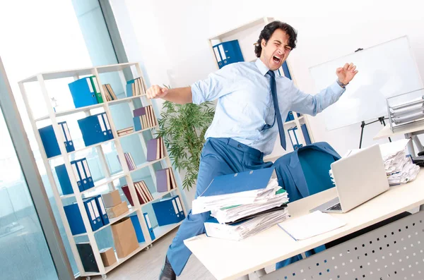 Jovem bonito masculino empregado com muito trabalho no escritório — Fotografia de Stock