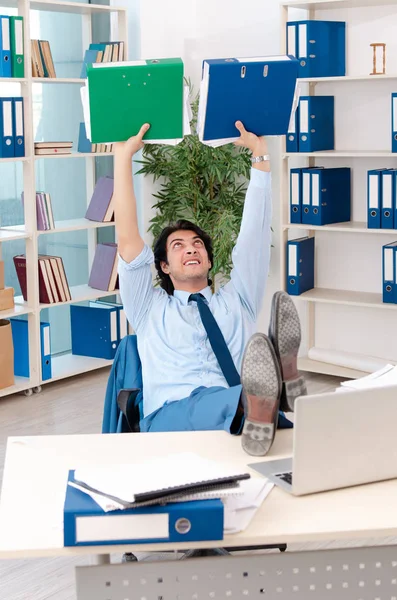 Young handsome male employee with too much work in the office — Stock Photo, Image