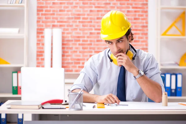 Byggevejleder, der arbejder med tegninger - Stock-foto