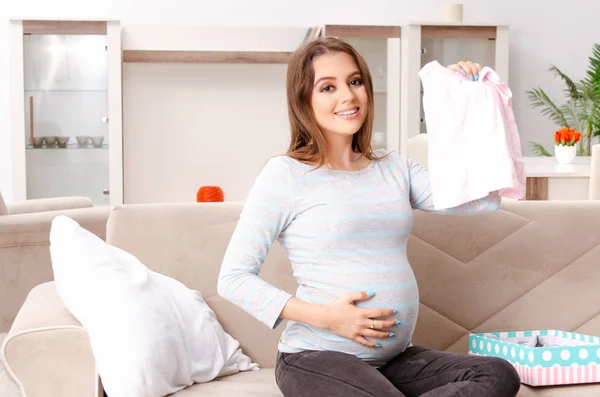 Giovane donna incinta seduta sul divano a casa — Foto Stock