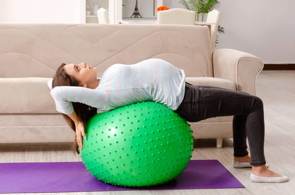 Mujer embarazada joven haciendo ejercicios deportivos en casa — Foto de Stock